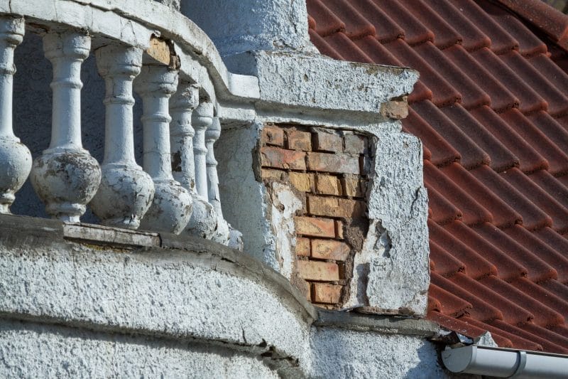 Afsprækkede murværk og gammel altan med afskalning